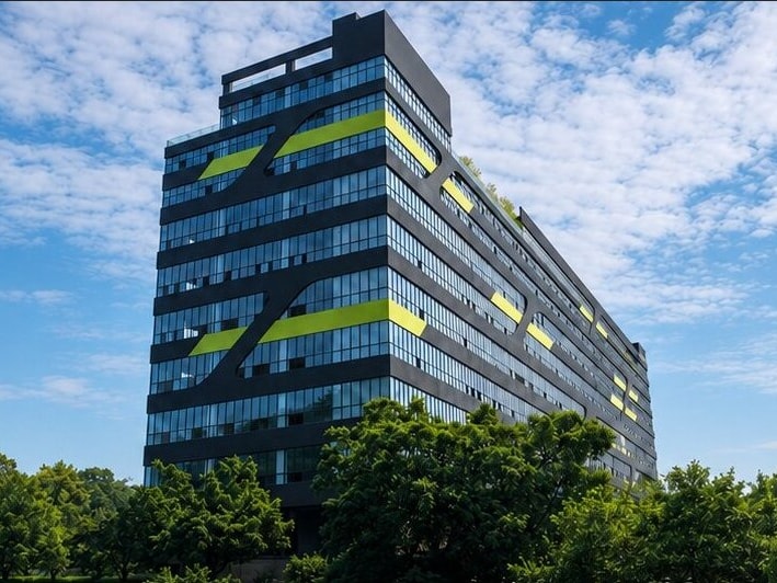 The production building seen from below, against open sky